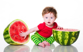 Маленький мальчик с половинами арбуза на белом фоне