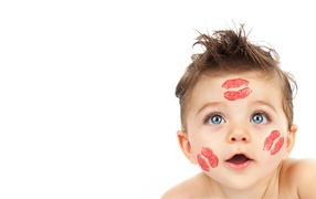 Little boy with traces of kisses on his face on a white background