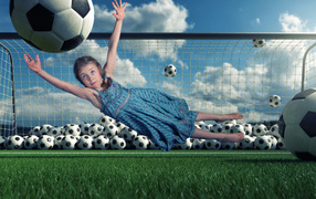 Little girl goalkeeper catches the ball at goal