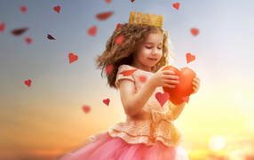 Маленькая девочка в костюме принцессы с красным сердцем в руках