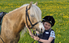 Little girl in helmet with horse