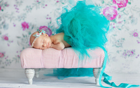Маленькая девочка спит в красивом бирюзовом платье