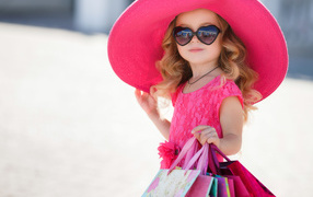 Маленькая девочка модница в большой розовой шляпе