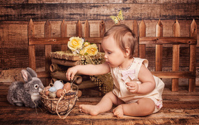 Маленькая девочка с корзиной яиц и плюшевым зайцем