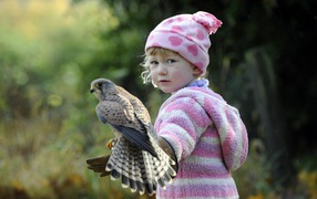 Little girl with a bird a falcon on her hand
