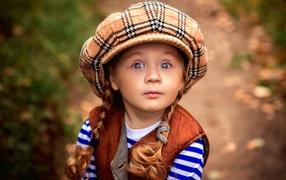 Little red-haired girl in a big cap