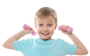 Маленький улыбающийся мальчик с гантелями на белом фоне