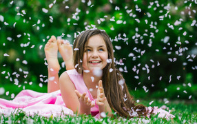 Little smiling girl, brown-haired woman catches petals