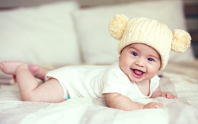 Smiling baby in a funny knitted hat