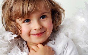 Маленькая голубоглазая девочка в костюме ангела 