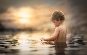 The little boy bathes in water