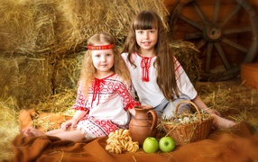 Две маленькие девочки в красивых костюмах с угощениями