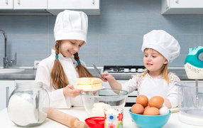 Две маленькие девочки на кухне готовят пирог