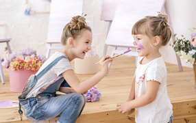 Две маленькие девочки играют с красками