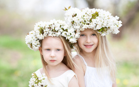 Две маленькие девочки с венками из белых цветов на голове