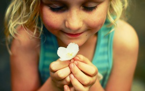 Маленькая девочка  держит белый цветок 