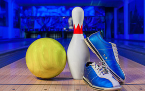 Синие кроссовки, шар и кегля на дорожке для боулинга