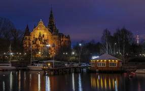 Храм в свете ночных фонарей у причала на реке, Стокгольм. Швеция