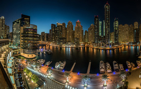 Panorama of night skyscrapers and wharf, Dubai. United Arab Emirates