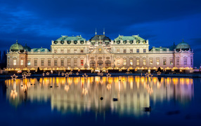 The Palace complex Belvedere at night is reflected in the pond, Vienna. Austria