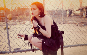 Актриса Эмилия Кларк в красивом черном платье в лучах солнца