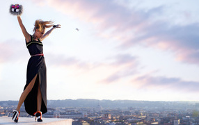 Актриса Кара Делевинь в черном платье на фоне неба 