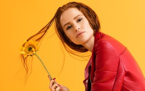 Actress Madeline Petsht in a red jacket photo on an orange background