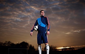 Футболист  Робин ван Перси с мячом на фоне неба