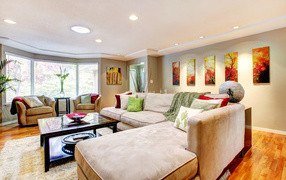 Большой диван в интерьере гостинной в пастельных тонах