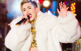 Популярная молодая певица Майли Сайрус в белой шубе на сцене