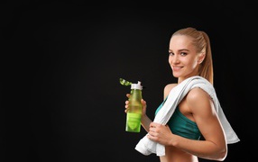 Sporty blonde girl with a bottle of water in her hand