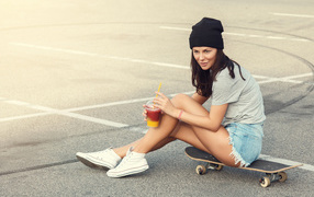 Sporty girl sitting on a skateboard