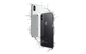 Thin smartphone iPhone X in drops of water on a white background
