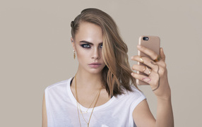 Молодая актриса Кара Делевинь с телефоном в руках