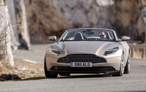 Серебристый кабриолет Aston Martin DB11 V8 Volante, 2018 года на дороге