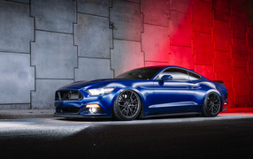 Синий автомобиль Ford Mustang GT у стены 