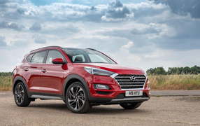 Красный автомобиль Hyundai Tucson, 2019 года под пасмурным небом