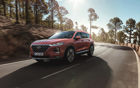 Красный автомобиль Hyundai Santa Fe, 2018 года на трассе