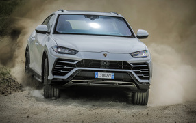 Белый автомобиль Lamborghini Urus  2018 года едет по дороге 