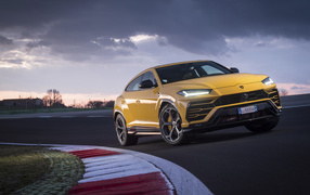 Желтый внедорожник Lamborghini Urus  едет по дороге