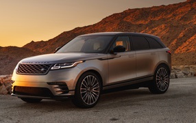 Серебристый внедорожник Land Rover 2018 года на фоне скалы 