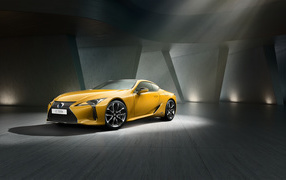 Желтый автомобиль Lexus LC 500 в сером здании
