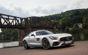 Серебристый автомобиль Mercedes-AMG GT на фоне моста
