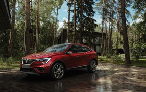 Красный стильный внедорожник Renault Arkana, 2018 года в лесу