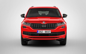 Красный автомобиль Skoda Kodiaq на сером фоне