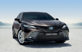 Автомобиль Toyota Camry Hybrid 2019 года стоит на песке