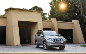 Серебристый внедорожник Toyota Land Cruiser Prado VX-L, 2018 года  в лучах солнца 