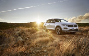 Серебристый внедорожник Volkswagen T-Roc, 2018 года на фоне солнца