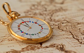 Карманные часы в золотой оправе лежат на карте