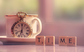 Часы с чашкой на столе с кубиками 